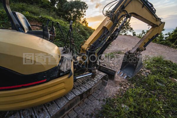 在日落天空的建筑工地上的現代挖掘機。