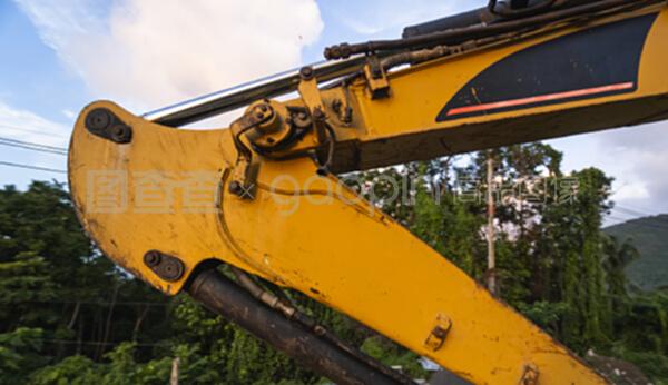 在日落天空的建筑工地上的現代挖掘機的詳細資料。